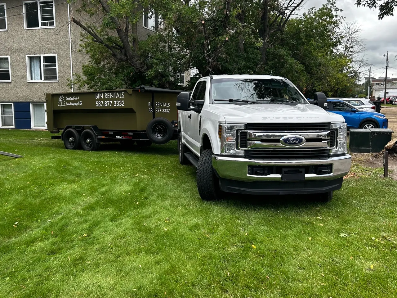 Truck and roll-off trailer setup used to deliver a 12-yard bin